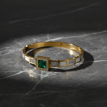 Gold cuff bangle with emerald green stone on dark luxury background