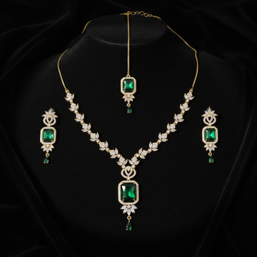 Gold emerald green bridal jewelry set with maang tikka on dark luxury background