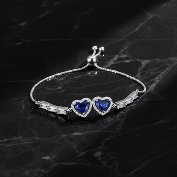 Silver double blue sapphire heart bracelet on dark luxury background