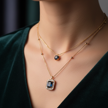 Gold double layer necklace with dark navy stone worn around neck