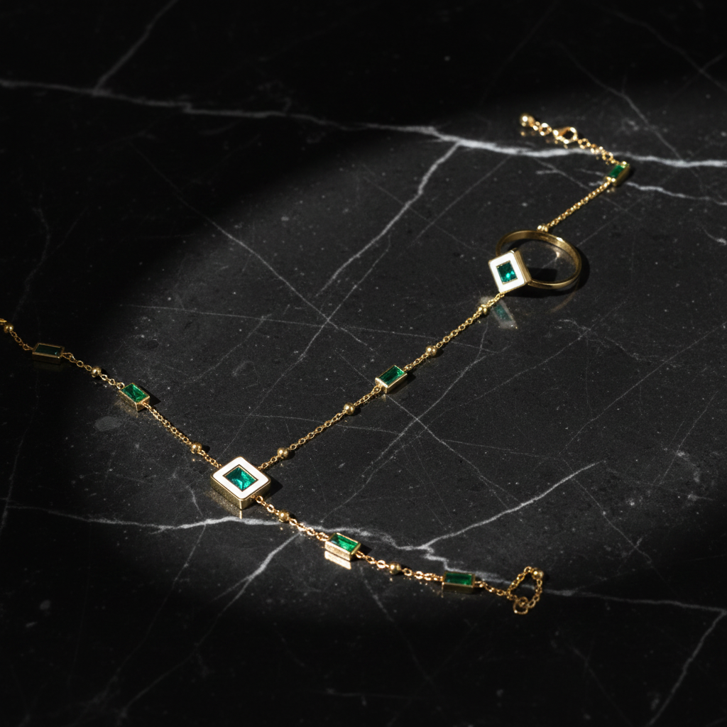 Gold hand chain bracelet ring set with emerald green stones on dark luxury background