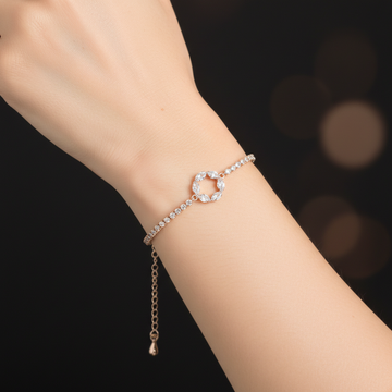Rose gold crystal tennis bracelet with circle charm worn on wrist