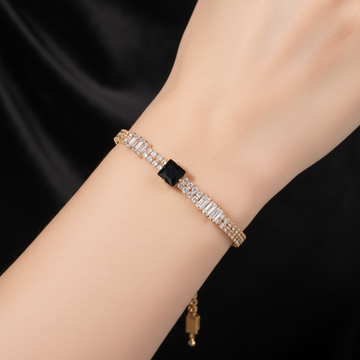 Gold double row crystal bracelet with black square center stone worn on wrist