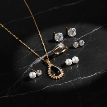Gold 5-piece black teardrop jewelry gift set on dark luxury background